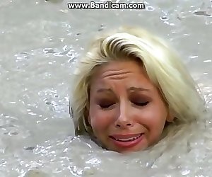 Bizarre Fetish Scene Featuring Busty Blonde Sinks In Lake Of Dirt
